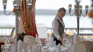 ATLANTIC Grand Hotel Travemünde Dame beim eindecken vom Tisch © ATLANTIC Hotels Management GmbH